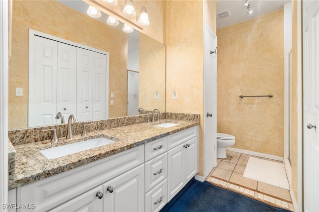 bathroom featuring tile patterned floors, vanity, and toilet