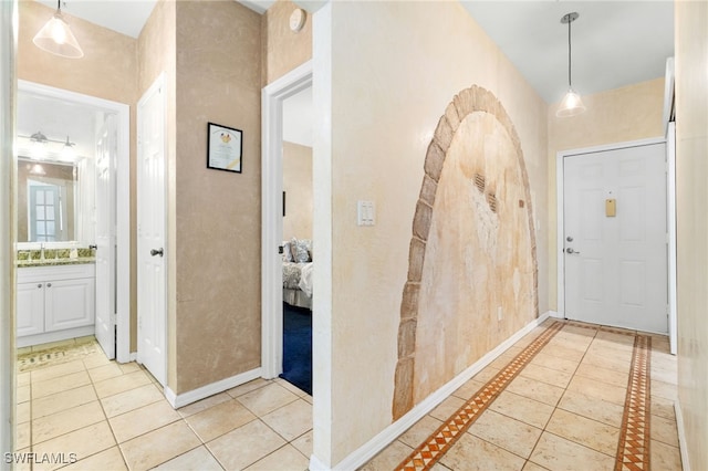 hall with sink and light tile patterned floors