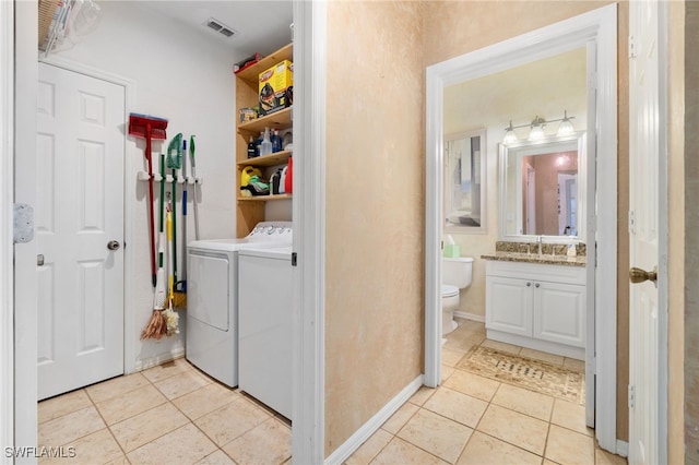 laundry room featuring light tile patterned floors, independent washer and dryer, and sink