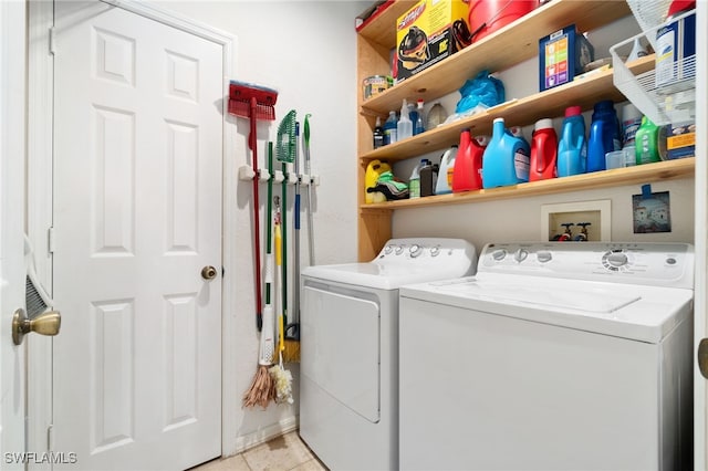 clothes washing area featuring washer and clothes dryer and light tile patterned floors