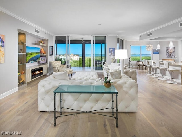 4800 Pelican Colony Blvd Unit 803, Bonita Springs, FL 34134 - living area featuring crown molding, a lit fireplace, and wood finished floors