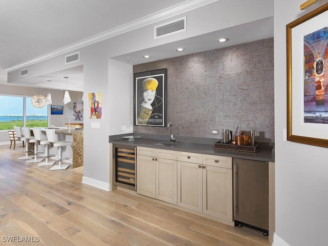 bar with ornamental molding, light hardwood / wood-style floors, sink, and wine cooler