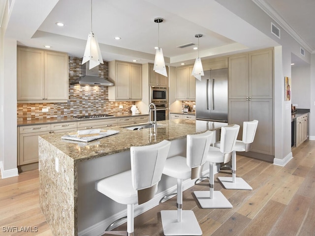 4800 Pelican Colony Blvd Unit 803, Bonita Springs, FL 34134 - kitchen with a tray ceiling, built in appliances, light wood-style flooring, backsplash, and a kitchen breakfast bar