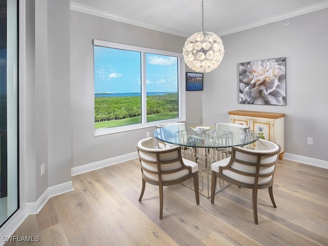 dining area featuring light wood-type flooring, an inviting chandelier, and crown molding