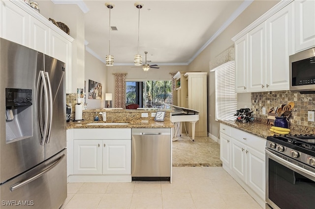 kitchen with white cabinetry, sink, appliances with stainless steel finishes, dark stone counters, and hanging light fixtures