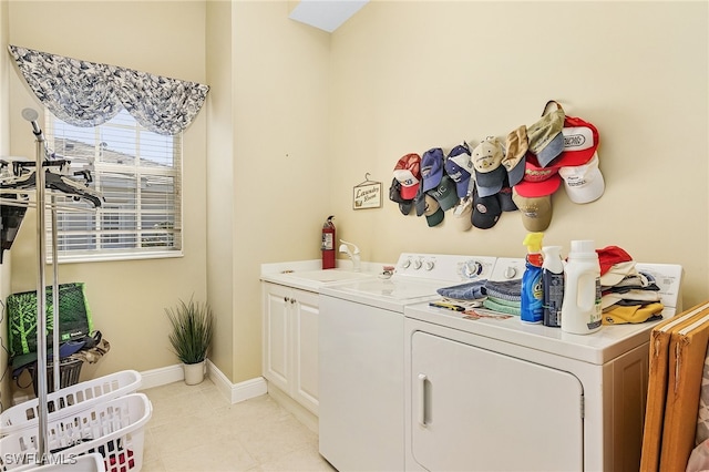 clothes washing area with cabinets, sink, and washer and dryer