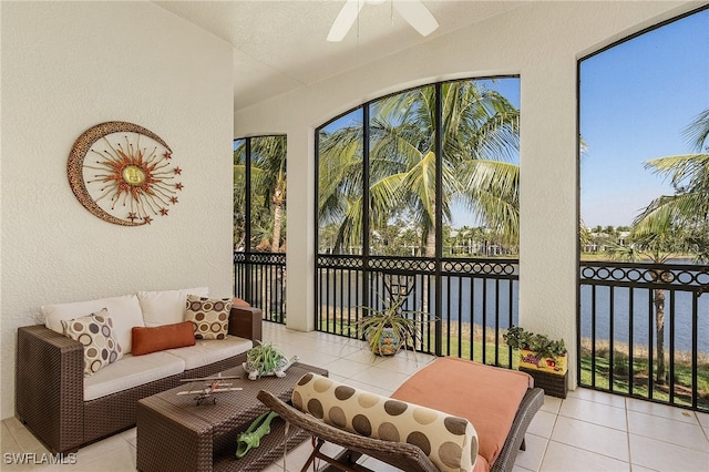 sunroom / solarium featuring ceiling fan and a water view