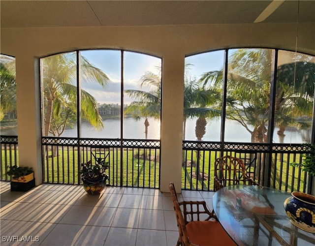 sunroom featuring a wealth of natural light and a water view