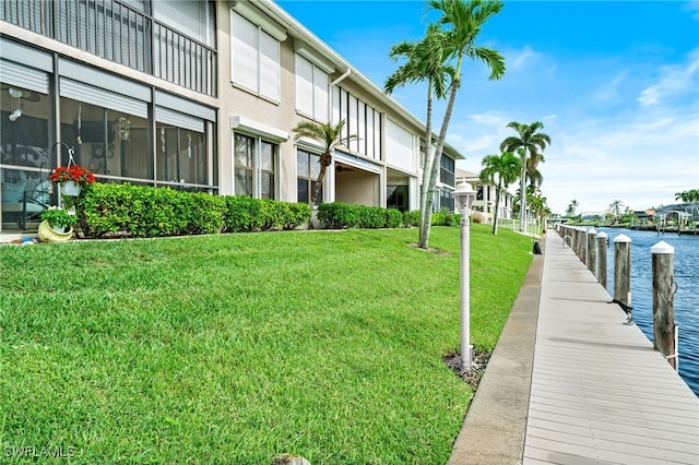 dock area featuring a lawn and a water view