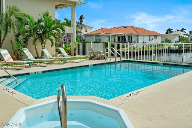 view of swimming pool with a community hot tub and a water view