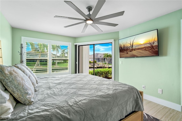 bedroom with hardwood / wood-style floors, access to outside, and ceiling fan