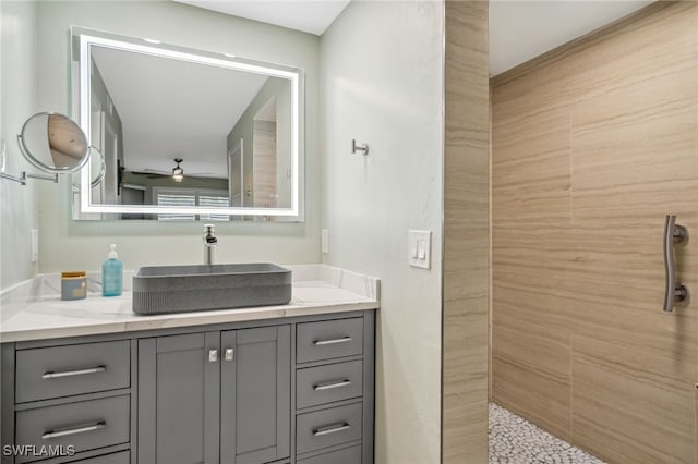 bathroom featuring a shower, vanity, and ceiling fan