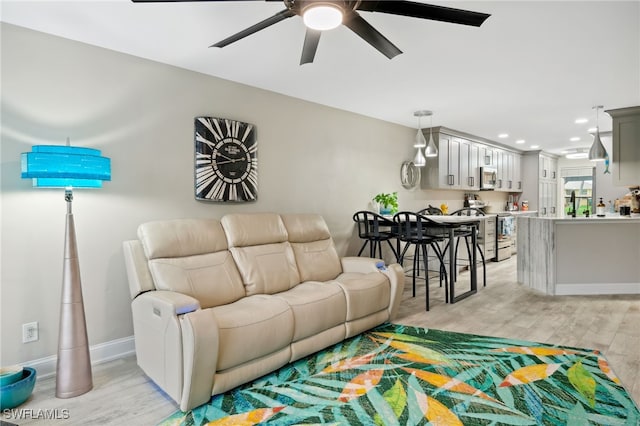 living room with ceiling fan and light hardwood / wood-style floors