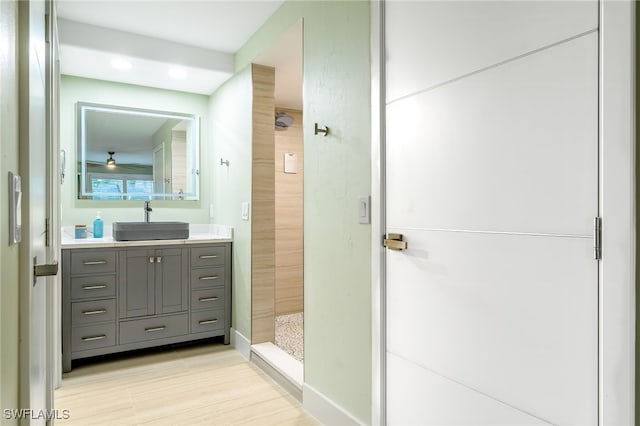 bathroom featuring walk in shower, vanity, and hardwood / wood-style flooring