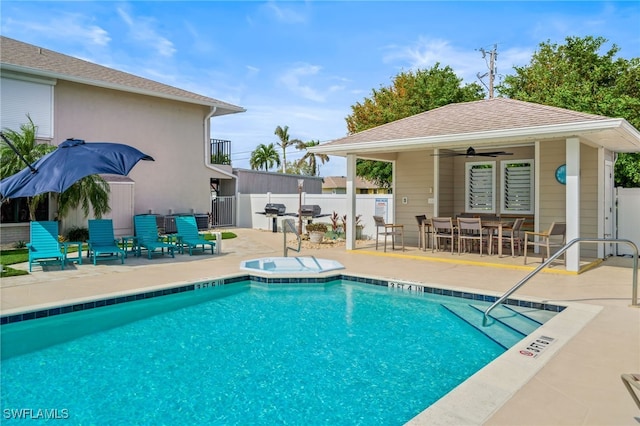 view of swimming pool featuring ceiling fan, a patio area, and a hot tub