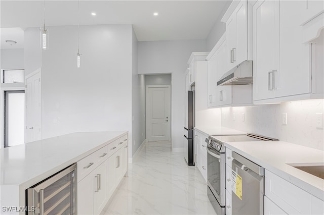 kitchen with white cabinetry, stainless steel appliances, decorative light fixtures, and beverage cooler