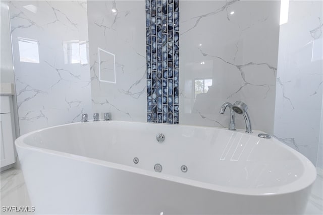 bathroom with a wealth of natural light and a bathing tub