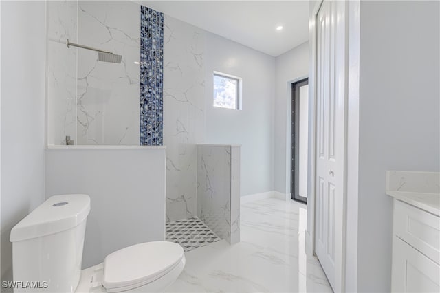 bathroom featuring tiled shower, toilet, and vanity