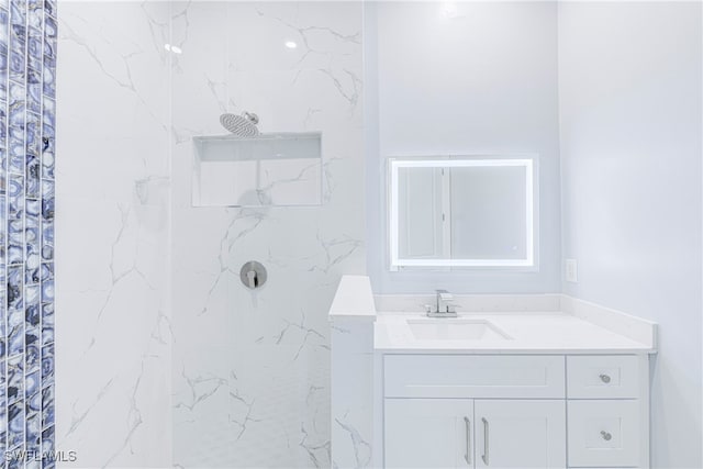 bathroom with vanity and a tile shower