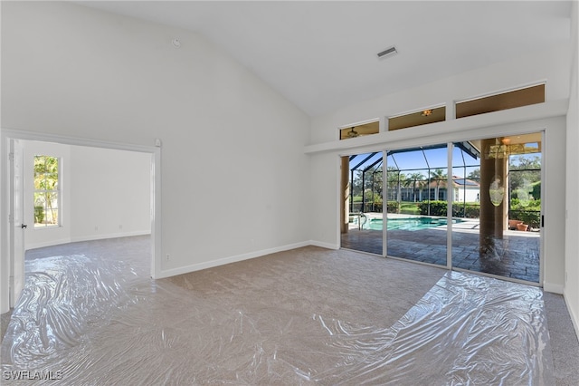 interior space with carpet and high vaulted ceiling