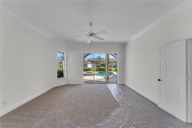 carpeted empty room with ceiling fan and crown molding