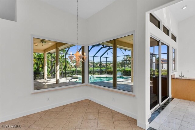 unfurnished dining area featuring light tile patterned floors, a wealth of natural light, and a high ceiling