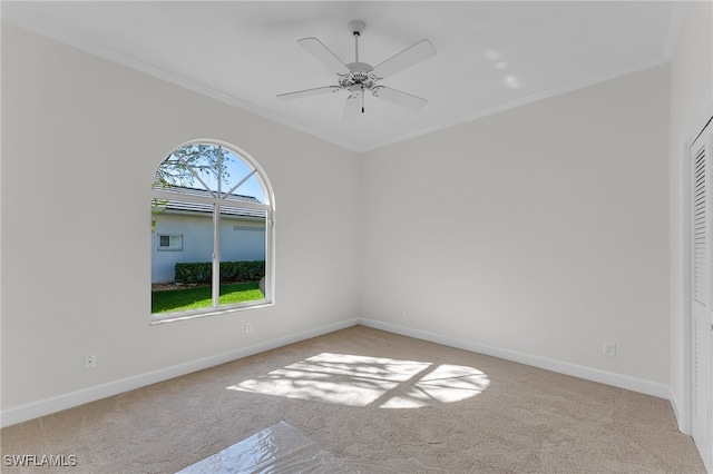 carpeted empty room featuring ceiling fan and crown molding