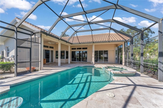 view of pool featuring ceiling fan, a patio area, an in ground hot tub, and glass enclosure