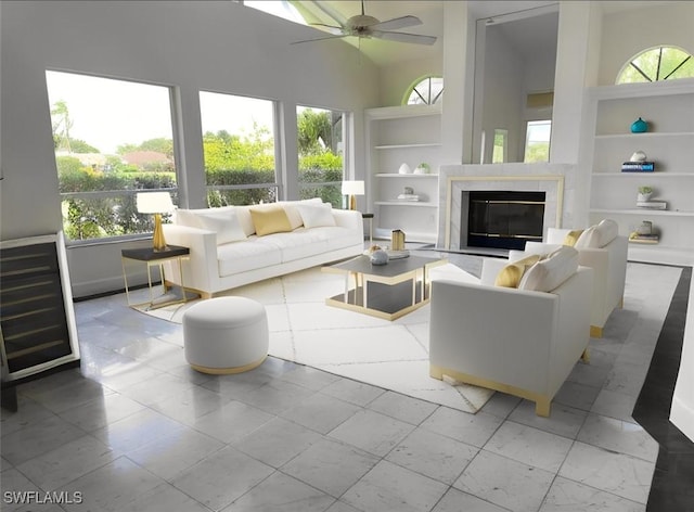 11752 Longshore Way W, Naples, FL 34119 - living area featuring built in features, ceiling fan, healthy amount of natural light, a high end fireplace, and a towering ceiling