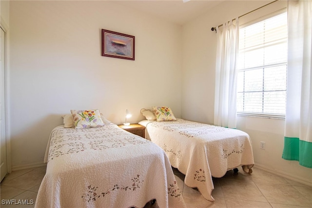 bedroom with multiple windows and light tile patterned floors