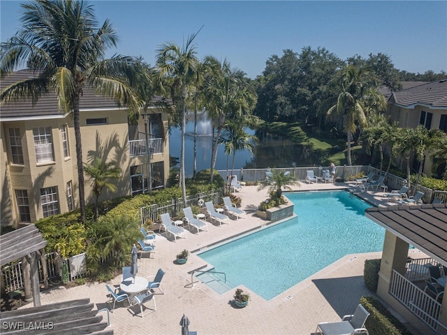 view of swimming pool featuring a water view and a patio area