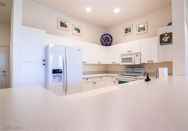 kitchen with white cabinetry, sink, and white appliances