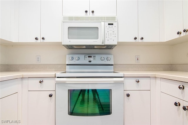 kitchen featuring white cabinets and white appliances