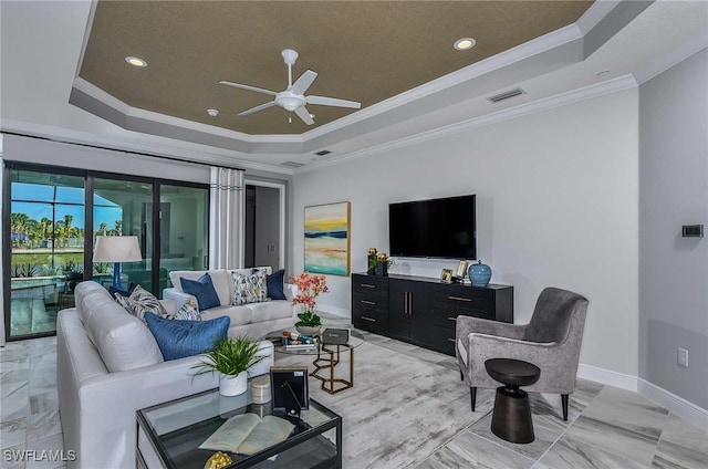 living room featuring ceiling fan, crown molding, and a tray ceiling