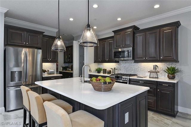 kitchen with a center island with sink, appliances with stainless steel finishes, a kitchen bar, backsplash, and decorative light fixtures