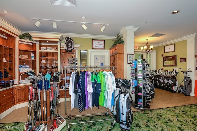 interior space featuring carpet, ornamental molding, an inviting chandelier, rail lighting, and decorative columns