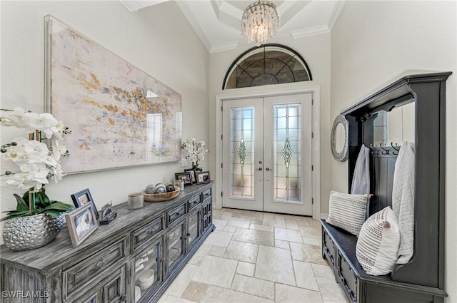 foyer with a high ceiling, french doors, a notable chandelier, and ornamental molding