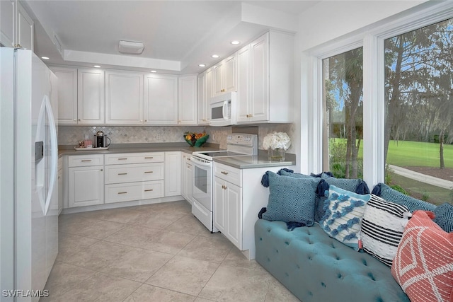 kitchen featuring white appliances, white cabinetry, light tile patterned floors, and tasteful backsplash