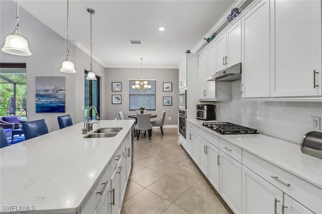 kitchen with white cabinetry, hanging light fixtures, a kitchen island with sink, and stainless steel appliances