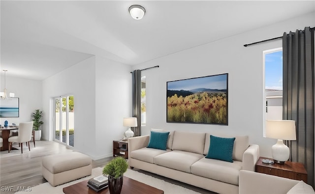 living room with hardwood / wood-style floors and a notable chandelier