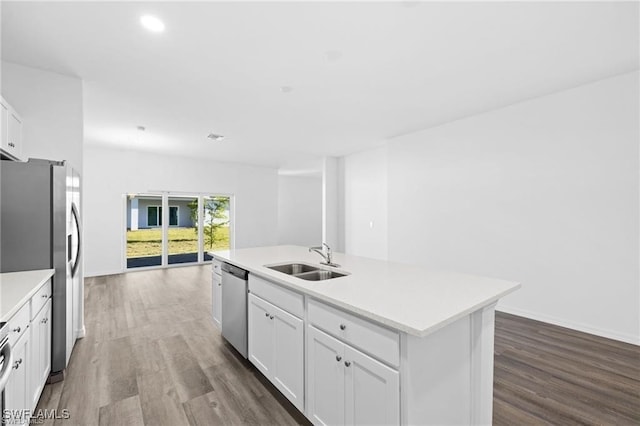 kitchen with hardwood / wood-style flooring, sink, appliances with stainless steel finishes, an island with sink, and white cabinets