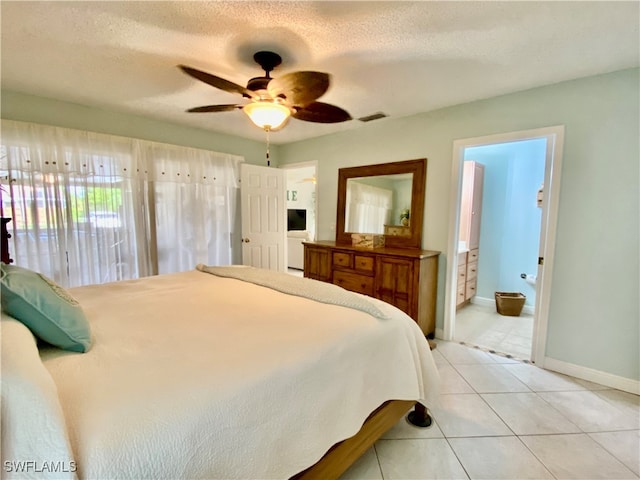 bedroom featuring ensuite bathroom, a textured ceiling, ceiling fan, and light tile patterned floors