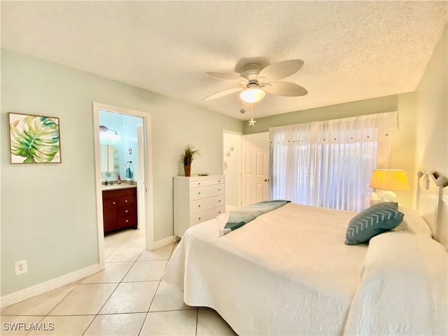 bedroom featuring light tile patterned flooring, sink, ceiling fan, a textured ceiling, and connected bathroom