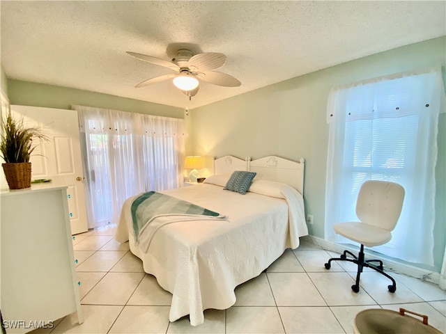 bedroom with a textured ceiling, light tile patterned floors, and ceiling fan