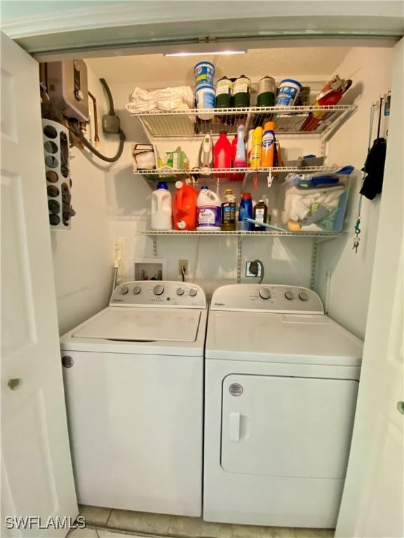 clothes washing area featuring washer and clothes dryer and tile patterned floors