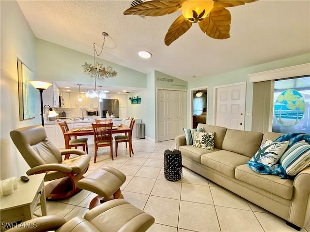 tiled living room with ceiling fan with notable chandelier, lofted ceiling, and a textured ceiling