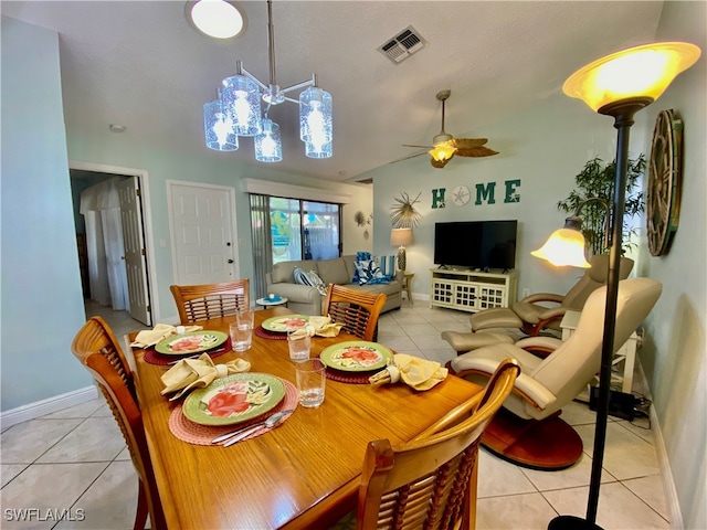 tiled dining room with vaulted ceiling and ceiling fan with notable chandelier