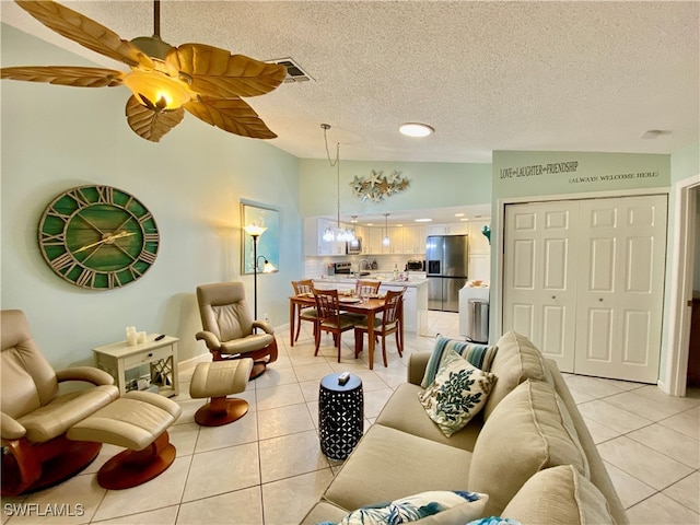 tiled living room featuring vaulted ceiling, ceiling fan, and a textured ceiling