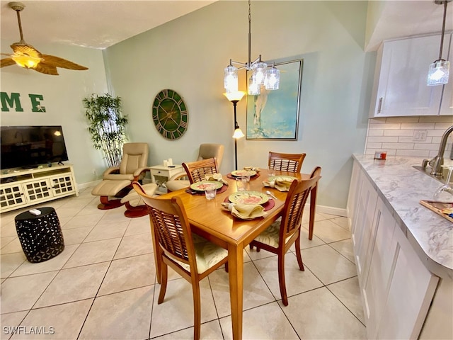 dining area featuring light tile patterned flooring, ceiling fan with notable chandelier, and high vaulted ceiling