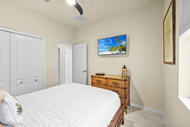 bedroom with ceiling fan, light hardwood / wood-style floors, and a closet